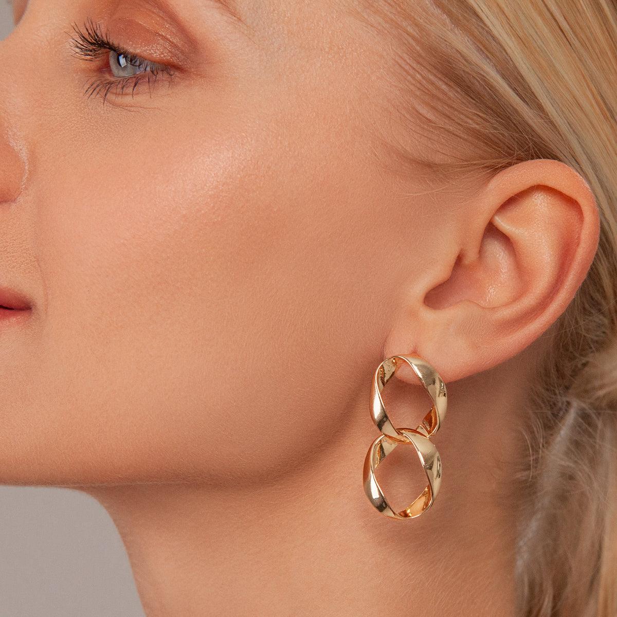 Model wearing Zaha Abstract Twisted Circles Drop Earrings in Gold