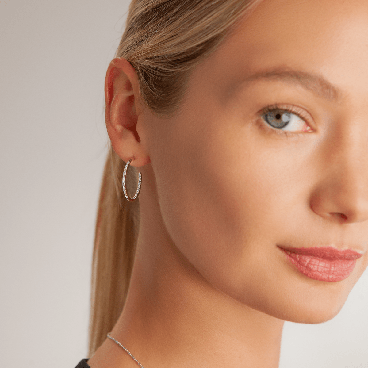 Model wearing Kylie Contemporary Crystal Hoop Earrings In Silver