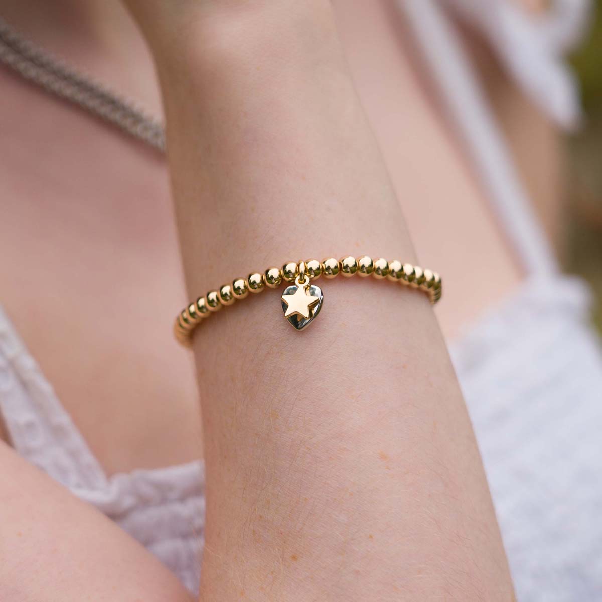Model wearing Gold and Silver Emily Heart and Star Elasticated Bracelet
