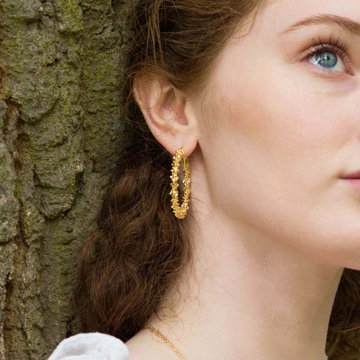 Model wearing Vivienne Textured Hoop Earrings In Gold