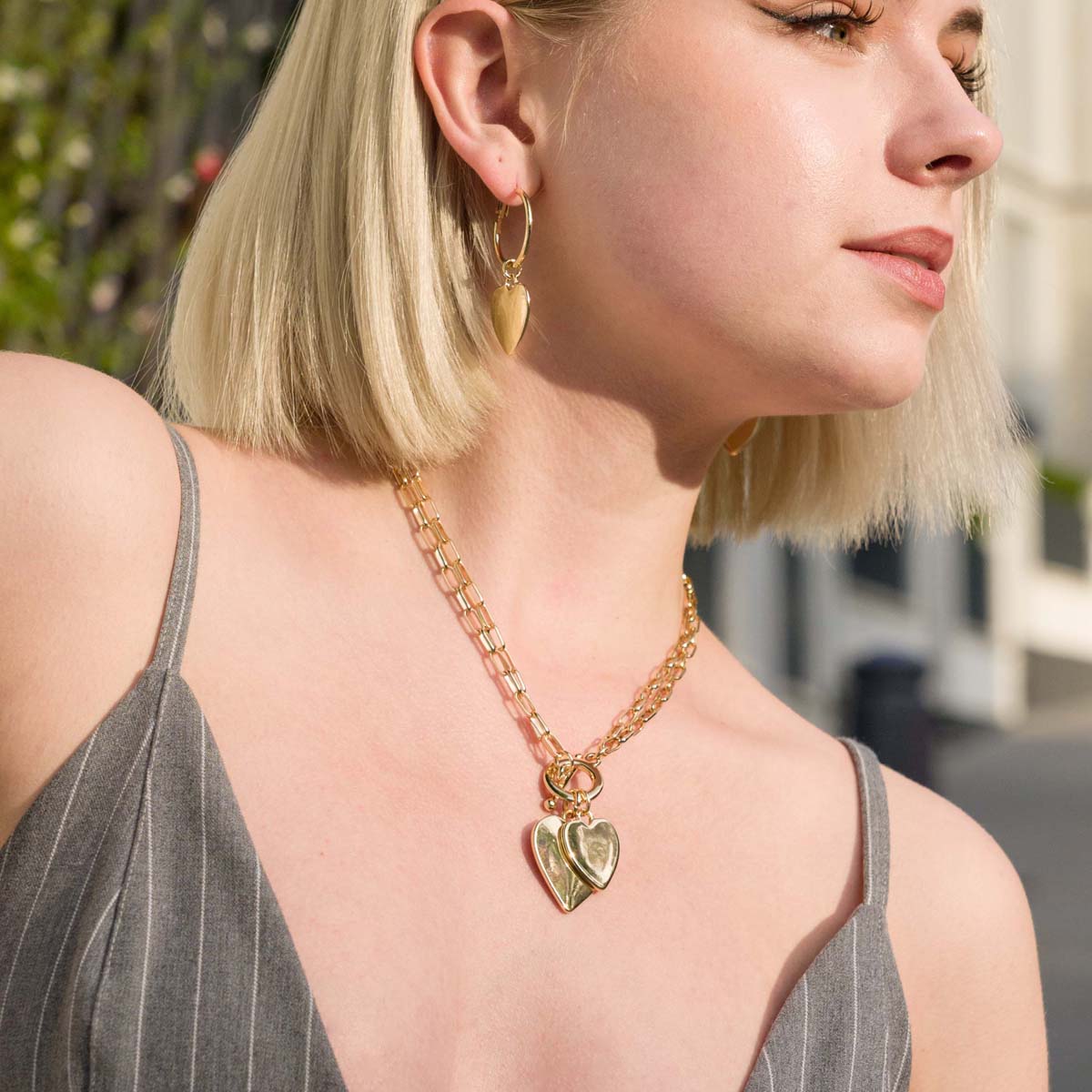 Model wearing Sweetheart Double Heart Pendant Bead Necklace In Gold