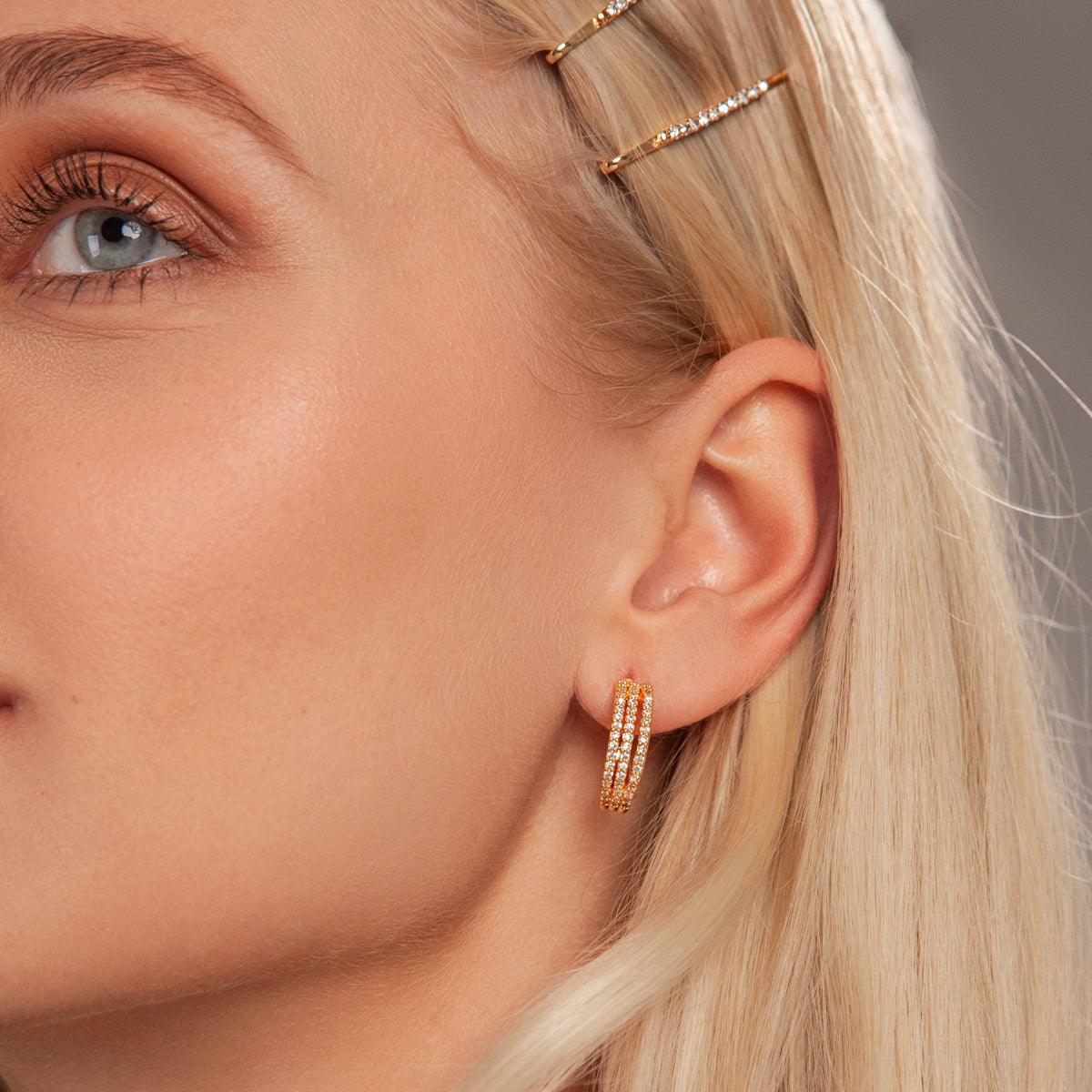 Model wearing Kylie Contemporary Crystal Earrings In Gold