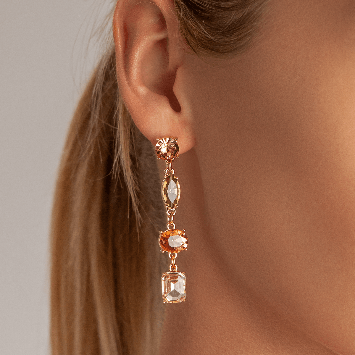 Model wearing Vivienne Gold & Multicoloured Crystal 4-Stone Dangle Earrings