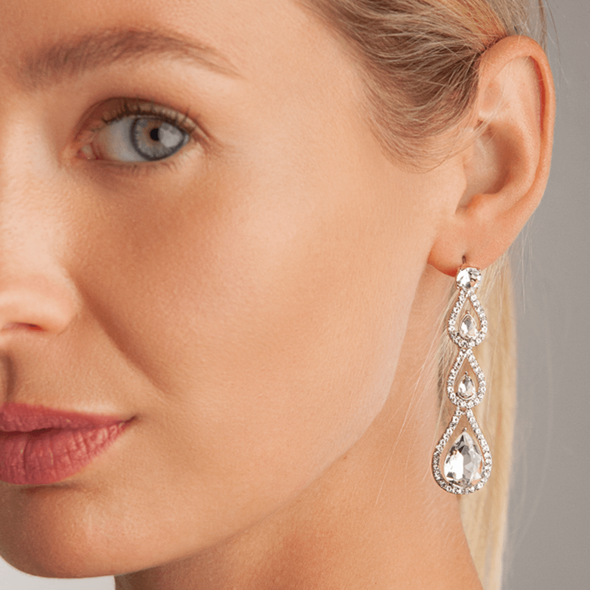 Model wearing Vivienne Teardrop 4-Stone Dangle Earrings In White Gold & Crystal
