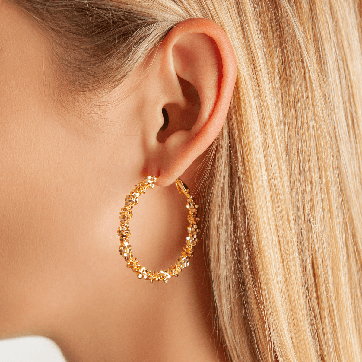 Model wearing Vivienne Textured Hoop Earrings In Gold