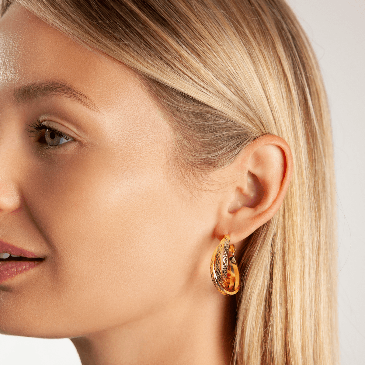 Model wearing Vivienne Twisted Hoop Earrings In Gold