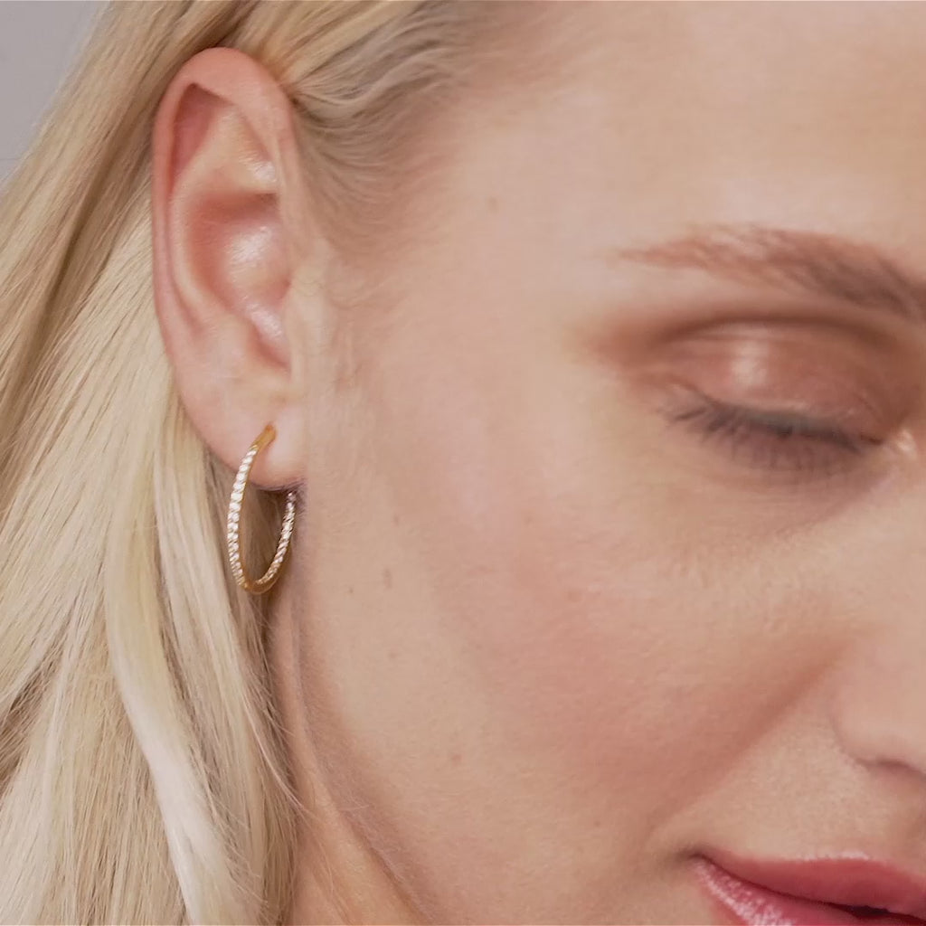 Model wearing Kylie Contemporary Crystal Hoop Earrings In Gold