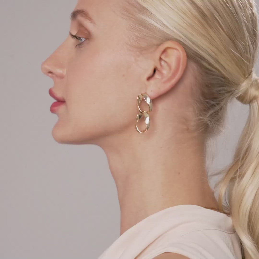 Model wearing Zaha Abstract Twisted Circles Drop Earrings in Gold